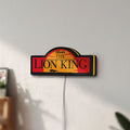 Unlit Lion King LED lightbox mounted on a wall in daylight