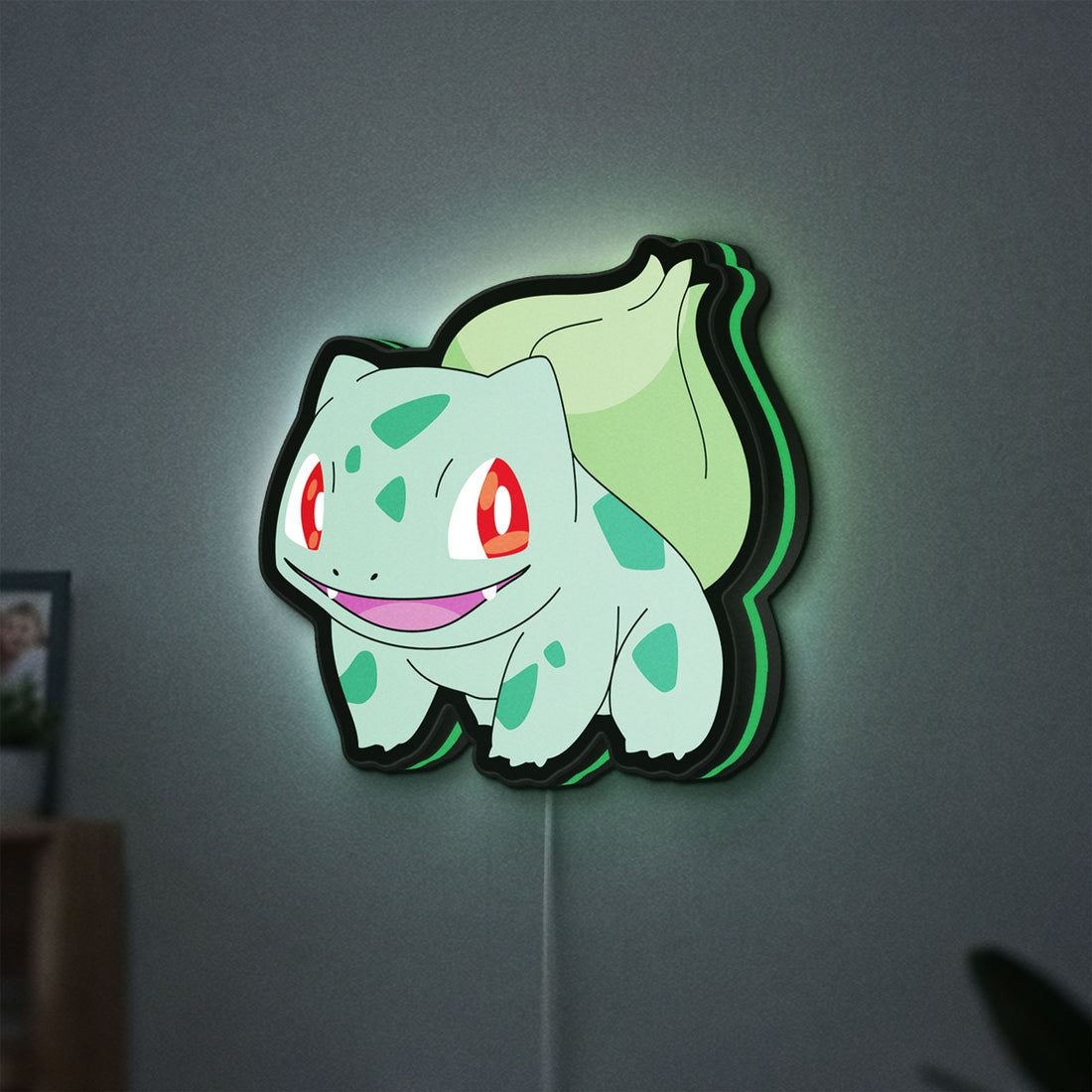 Bulbasaur LED lightbox hanging on a wall with green glow