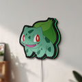 Unlit Bulbasaur LED lightbox mounted on a wall in daylight