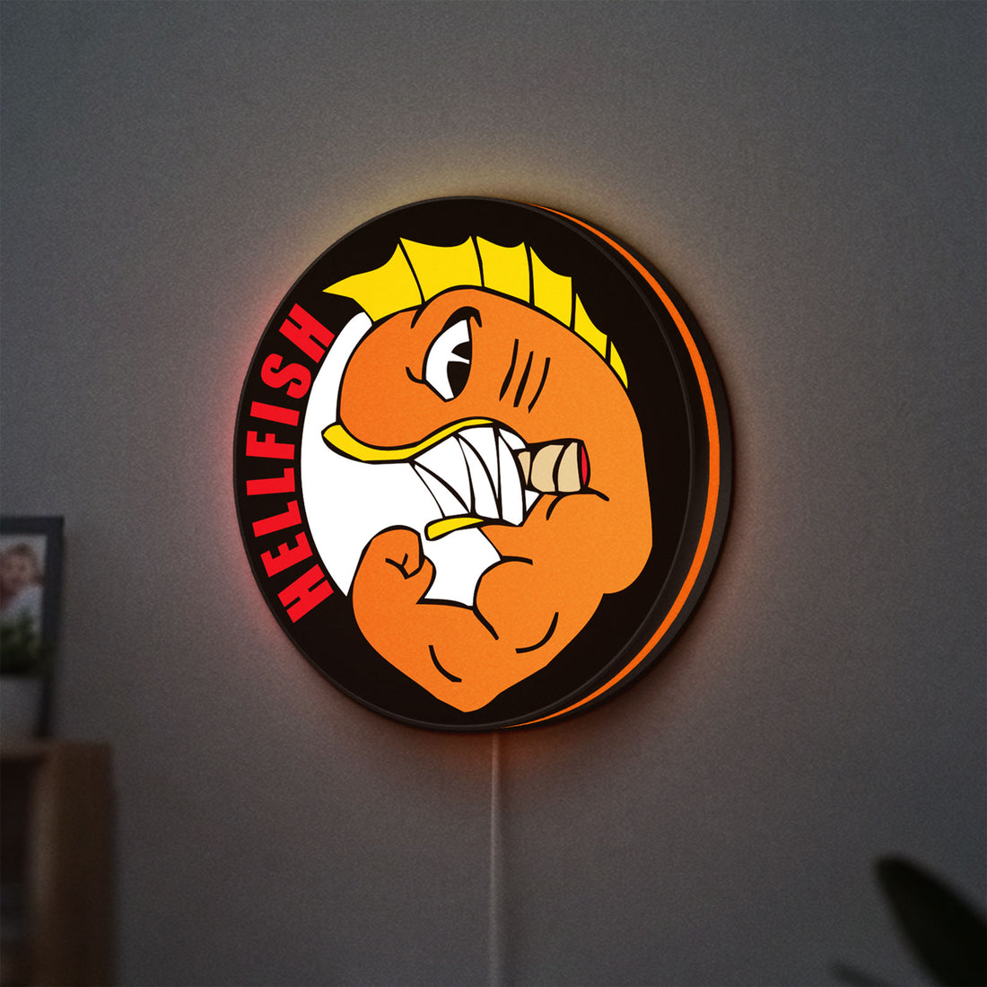 Hellfish LED lightbox hanging on a wall with orange glow