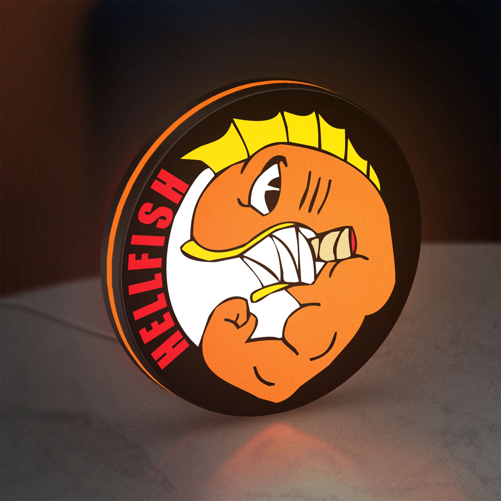 Hellfish LED lightbox standing on a desk from an angled side view with orange glow