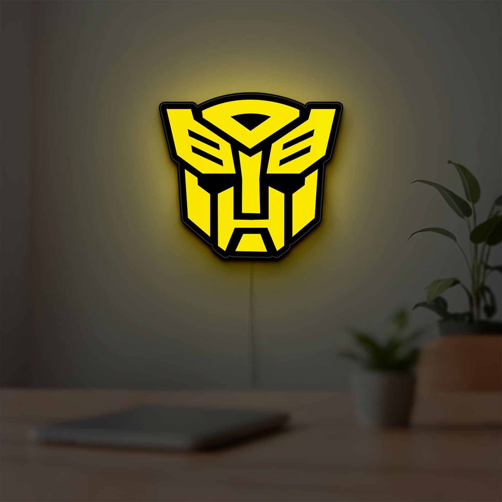 Autobots LED lightbox hanging on a room wall with soft yellow light