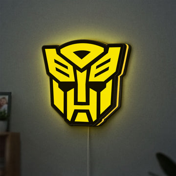 Autobots LED lightbox hanging on a wall with yellow glow