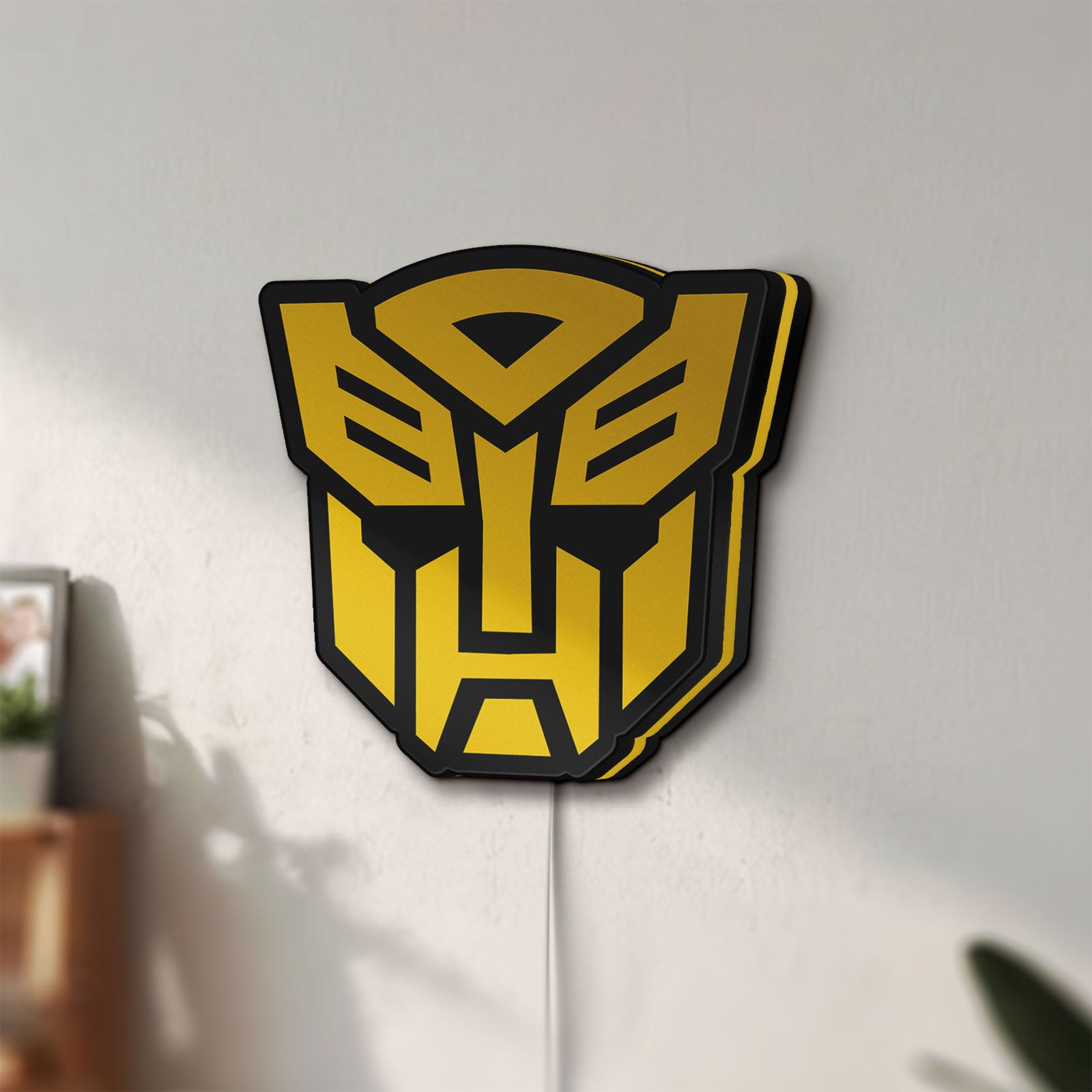 Unlit Autobots LED lightbox mounted on a wall in daylight