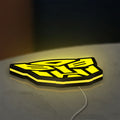 Autobots LED lightbox lying flat on a desk with yellow glow