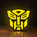 Front view of Autobots LED lightbox sign glowing on a wooden desk
