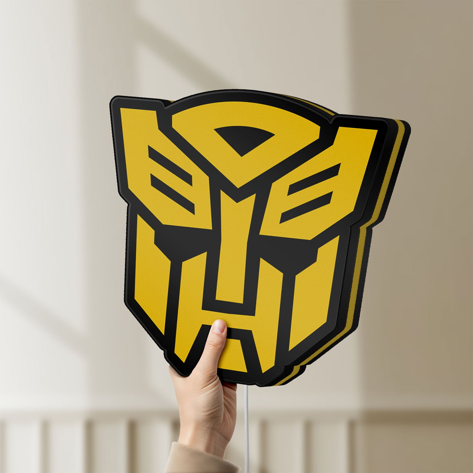 Unlit Autobots LED lightbox held by hand to show size and details