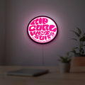 Rip Curl LED lightbox hanging on a room wall with soft pink light