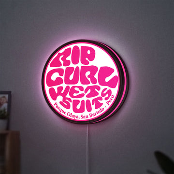 Rip Curl LED lightbox hanging on a wall with pink glow