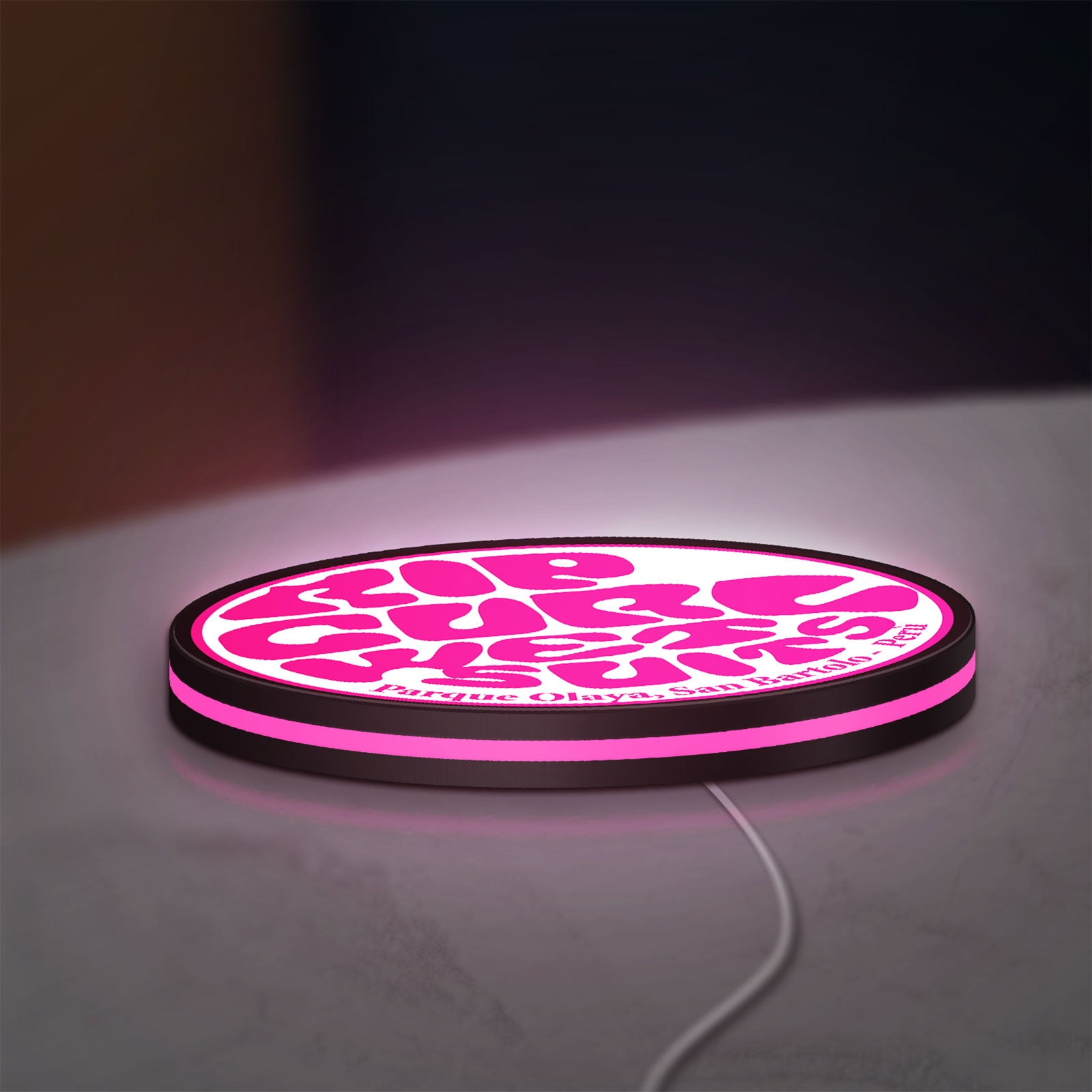 Rip Curl LED lightbox lying flat on a desk with pink glow