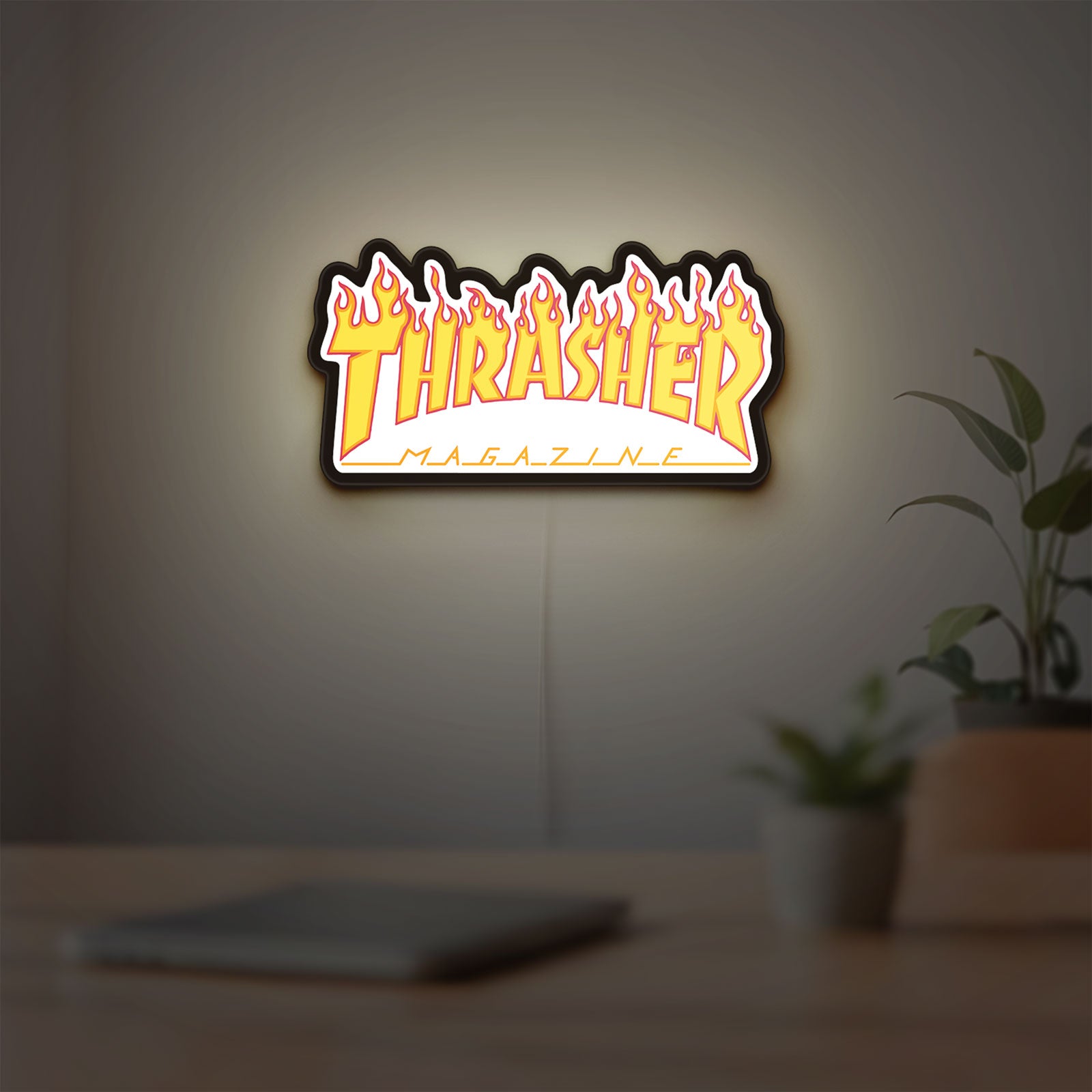 Thrasher Magazine LED lightbox hanging on a room wall with soft yellow light