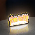 Thrasher Magazine LED lightbox standing on a desk from an angled side view with yellow glow