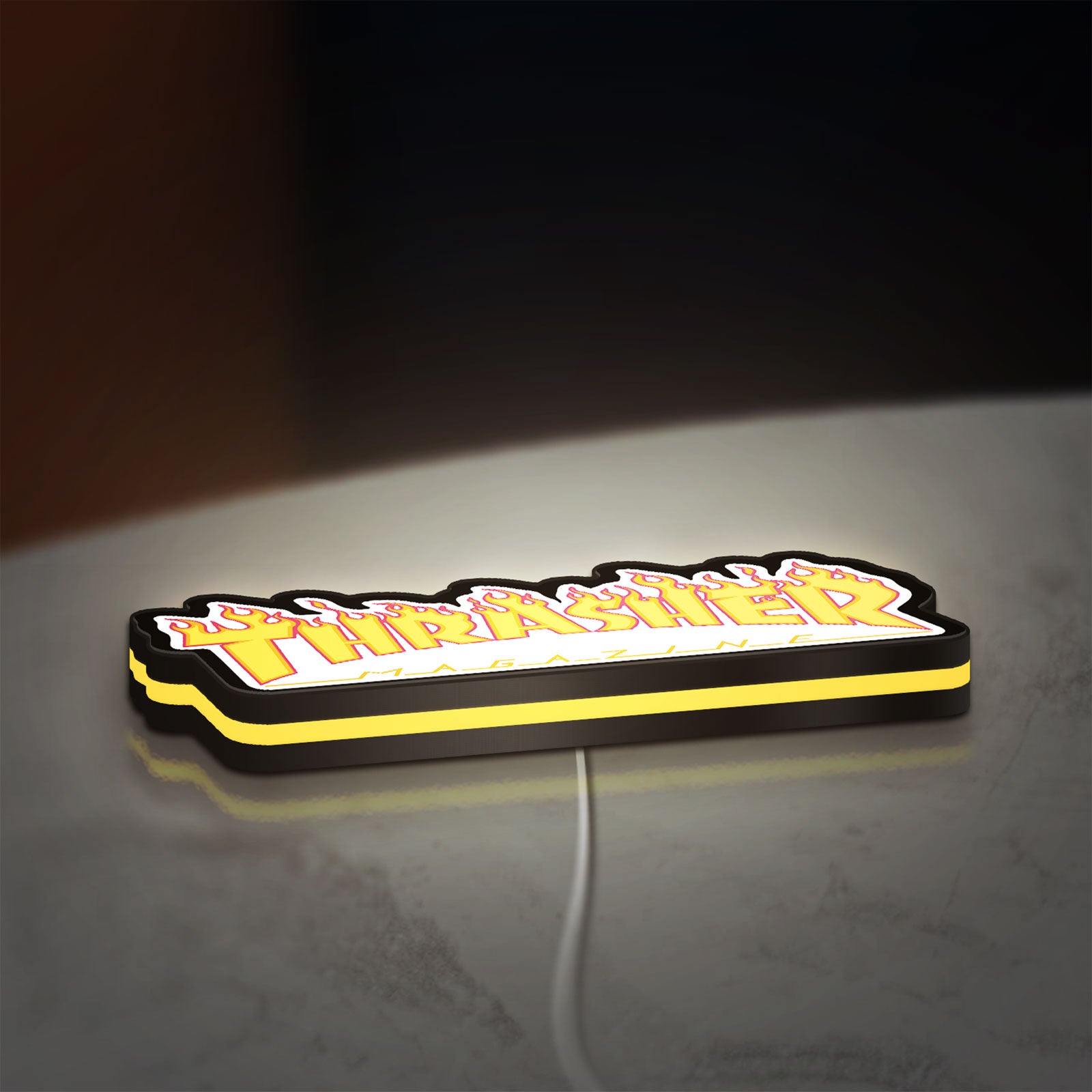 Thrasher Magazine LED lightbox lying flat on a desk with yellow glow