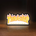Front view of Thrasher Magazine LED lightbox sign glowing on a wooden desk
