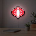 G.I. Joe Cobra LED lightbox hanging on a room wall with soft red light