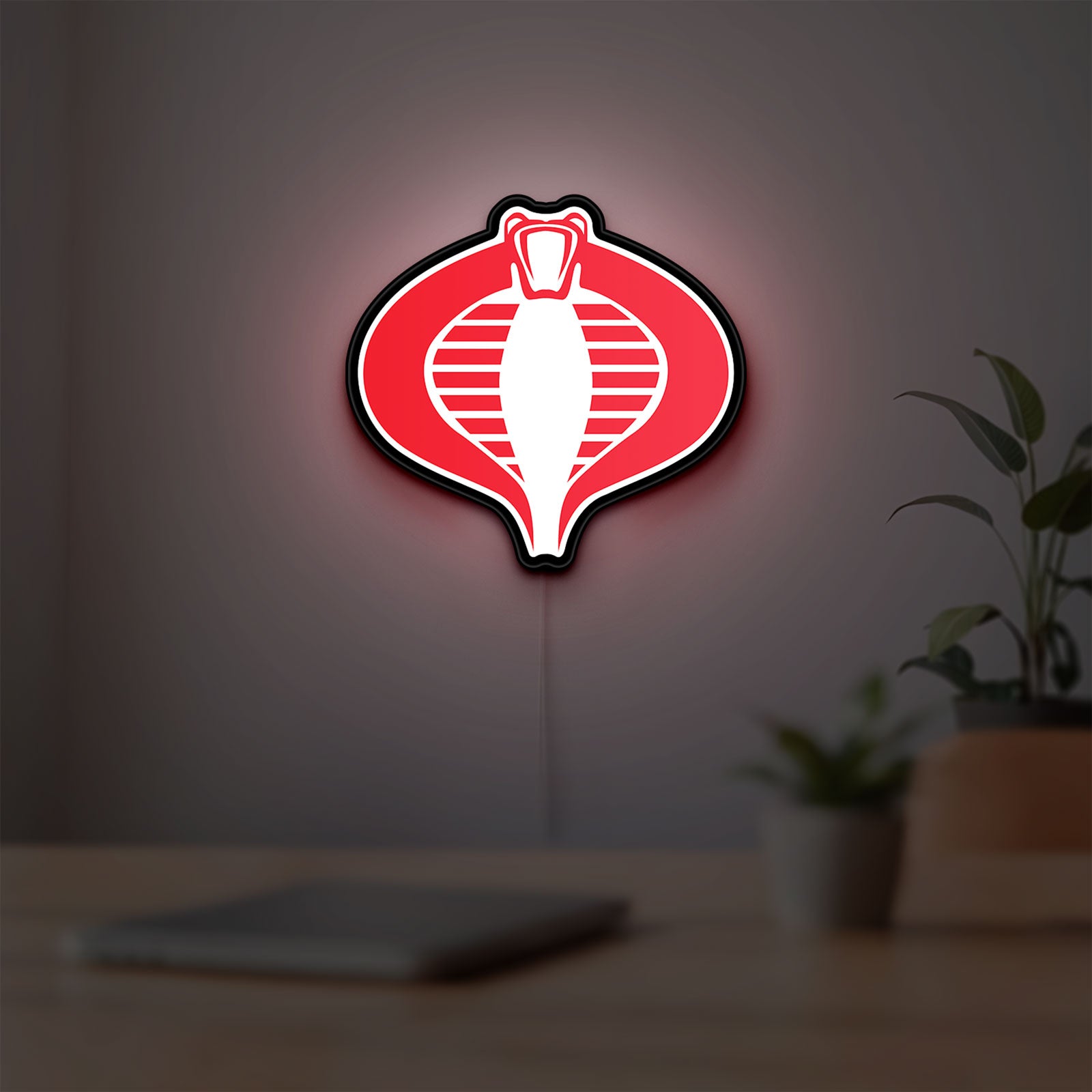 G.I. Joe Cobra LED lightbox hanging on a room wall with soft red light