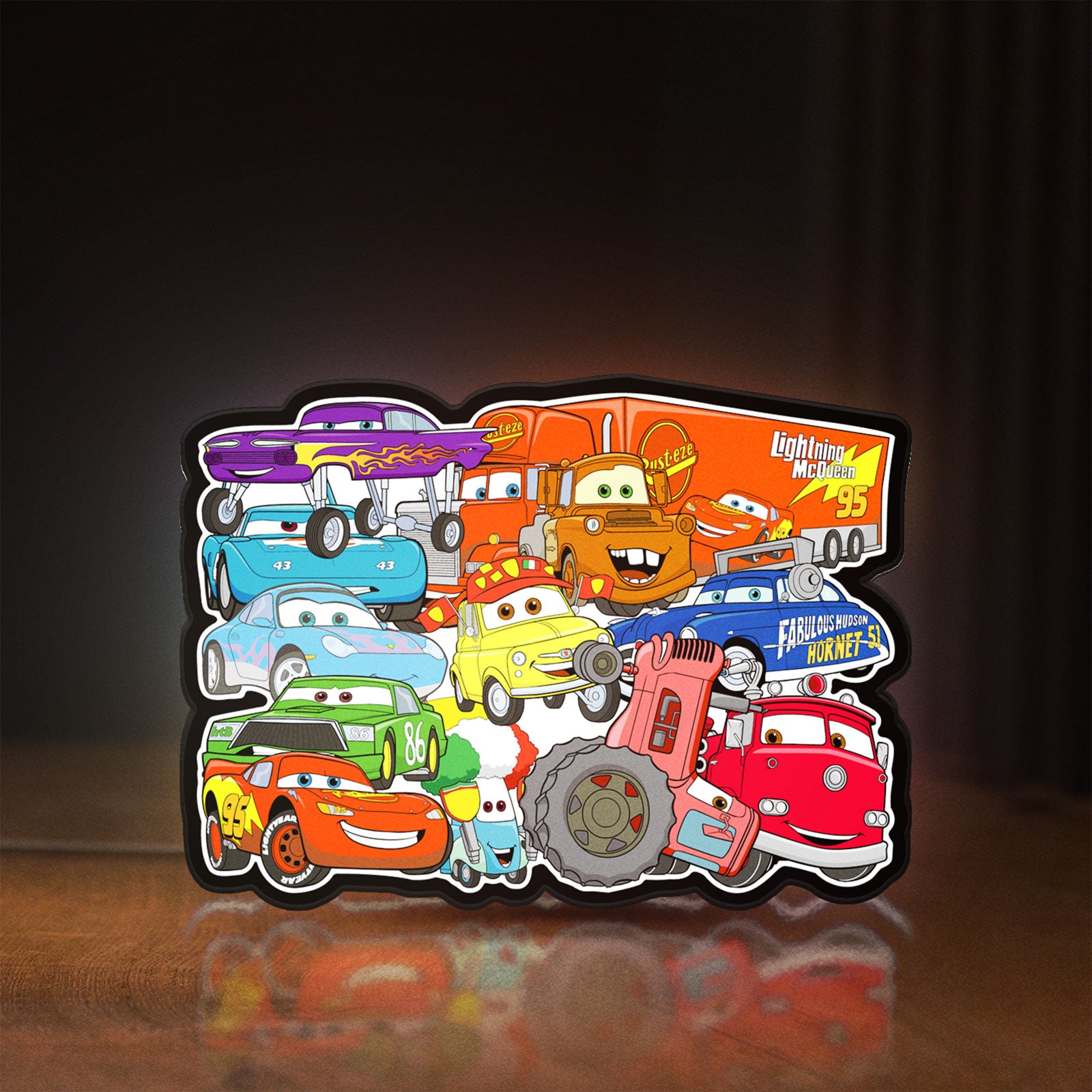 Front view of Disney's Cars Characters LED lightbox sign glowing on a wooden desk