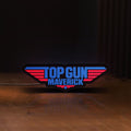 Front view of Top Gun Maverick LED lightbox sign glowing on a wooden desk