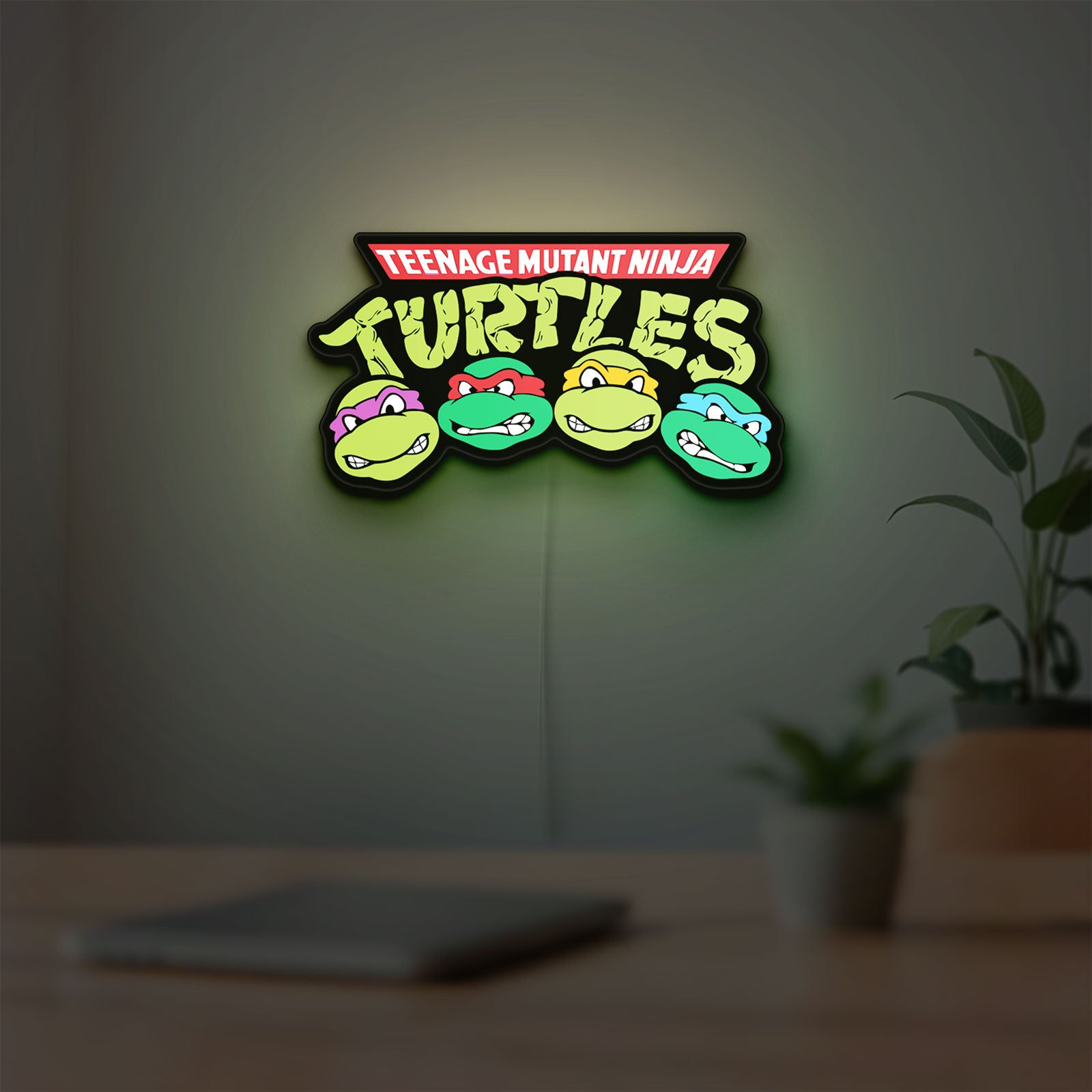 Teenage Mutant Ninja Turtles LED lightbox hanging on a room wall with soft green light