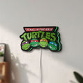 Unlit Teenage Mutant Ninja Turtles LED lightbox mounted on a wall in daylight