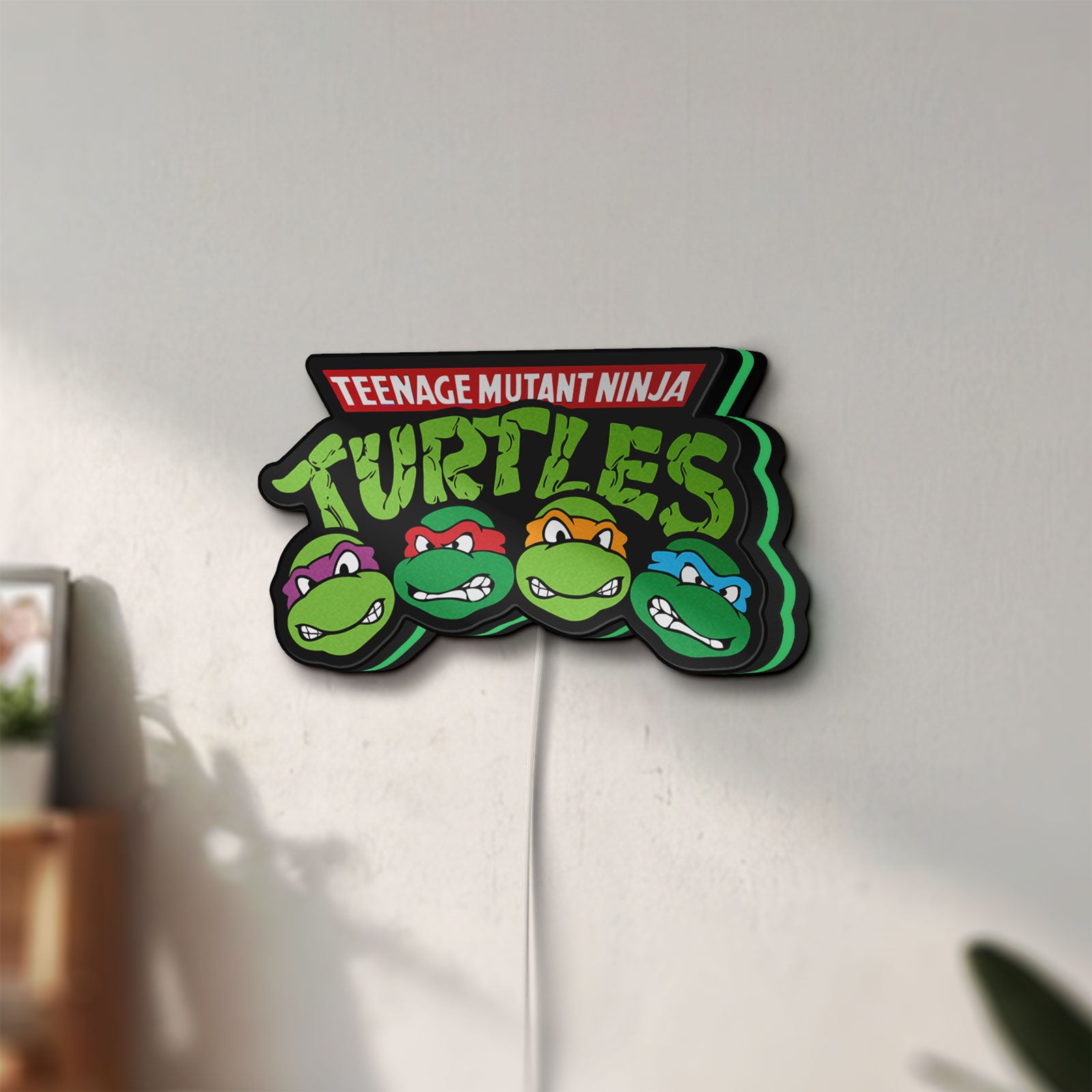 Unlit Teenage Mutant Ninja Turtles LED lightbox mounted on a wall in daylight