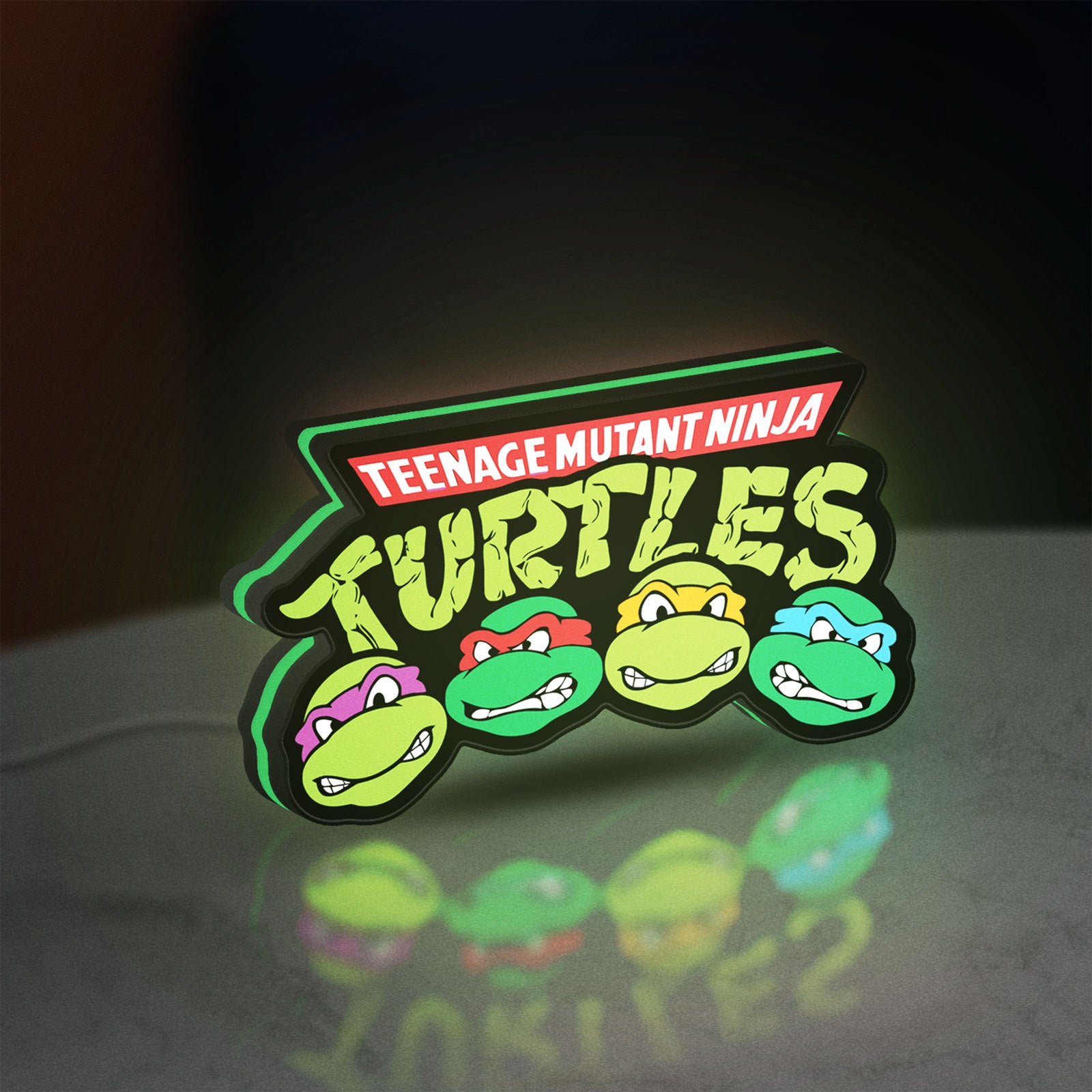 Teenage Mutant Ninja Turtles LED lightbox standing on a desk from an angled side view with green glow