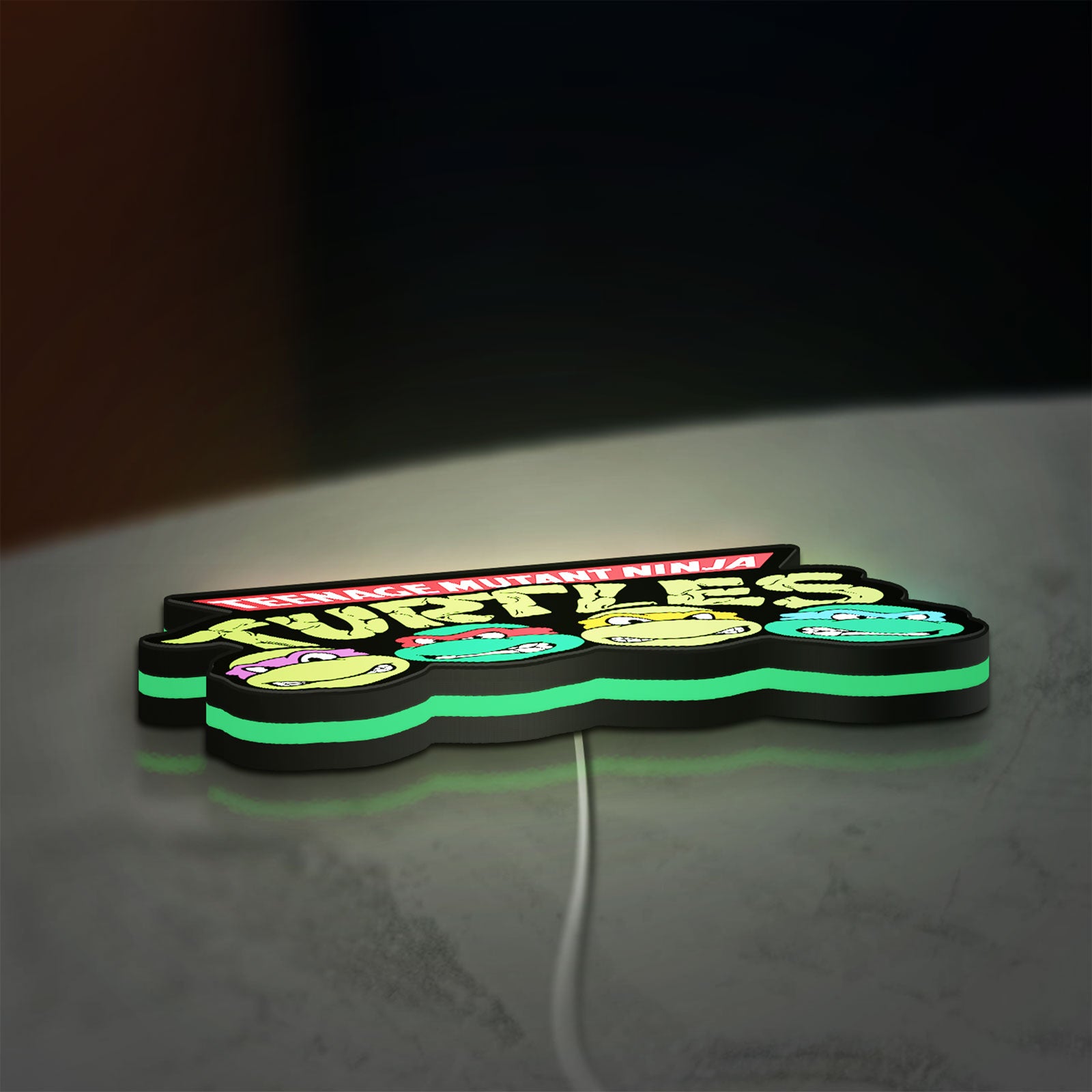 Teenage Mutant Ninja Turtles LED lightbox lying flat on a desk with green glow