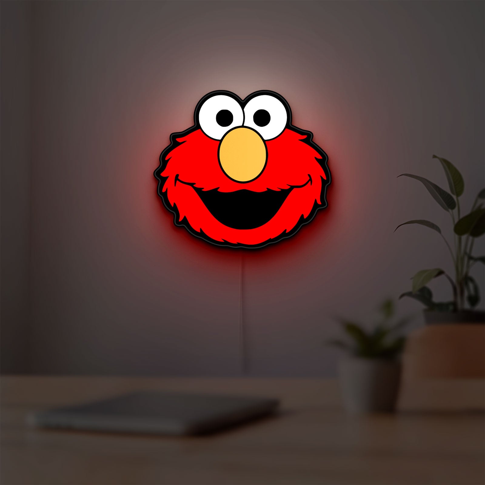 Elmo LED lightbox hanging on a room wall with soft red light