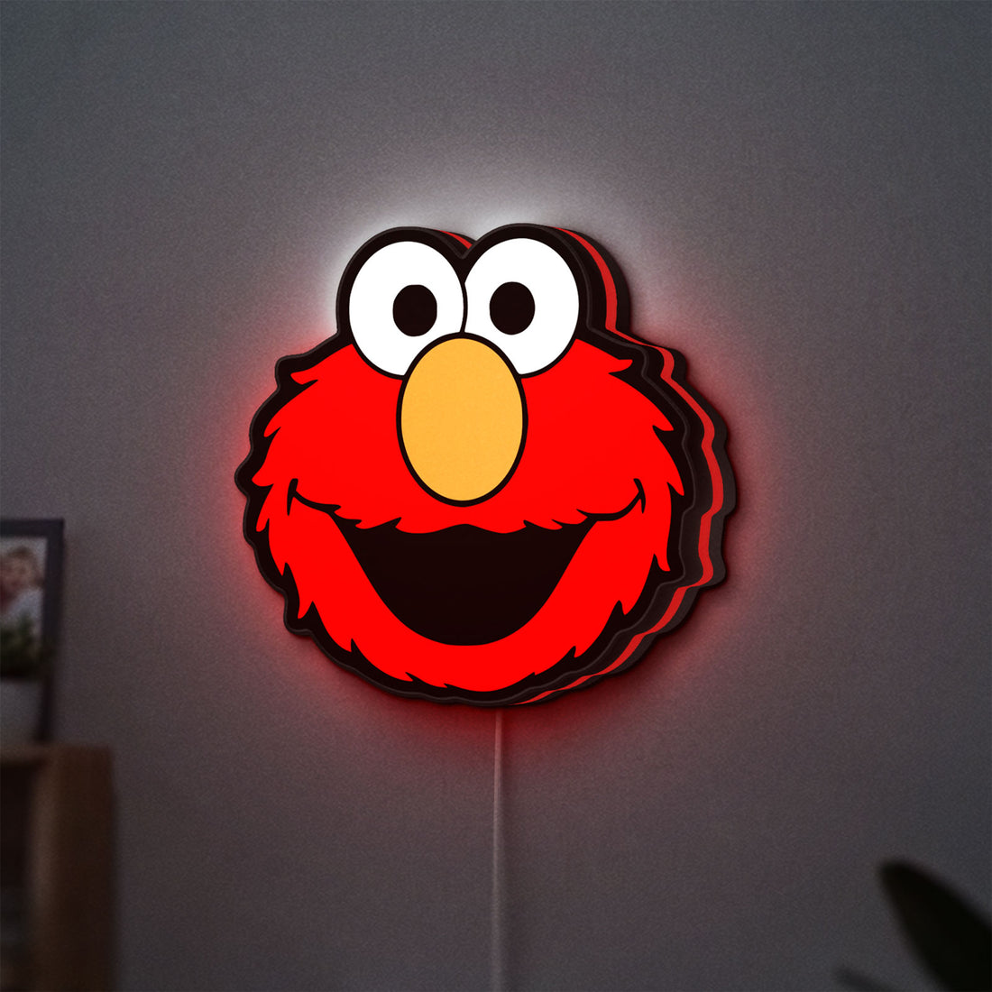 Elmo LED lightbox hanging on a wall with red glow