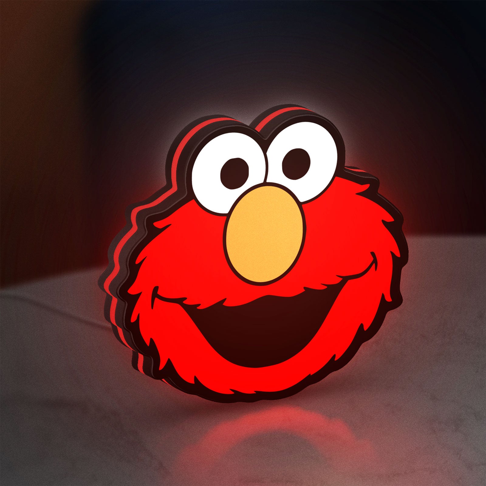 Elmo LED lightbox standing on a desk from an angled side view with red glow