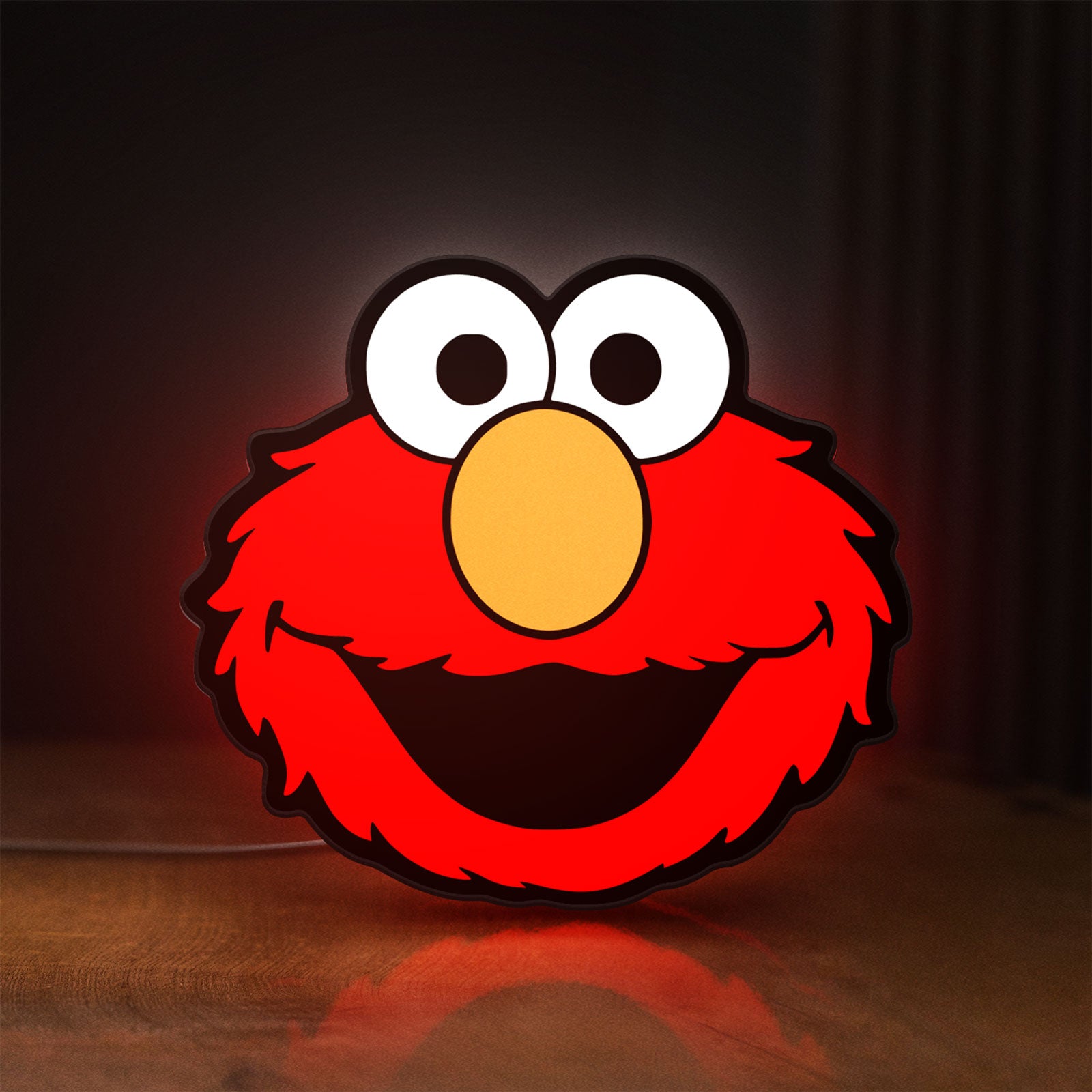 Front view of Elmo LED lightbox sign glowing on a wooden desk