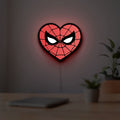 Spiderman Heart LED lightbox hanging on a room wall with soft red light