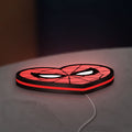 Spiderman Heart LED lightbox lying flat on a desk with red glow