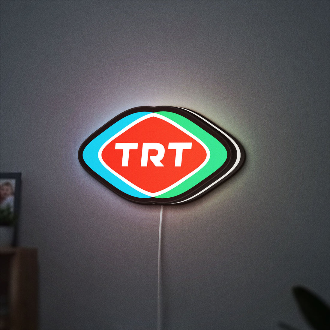 TRT LED lightbox hanging on a wall with white glow