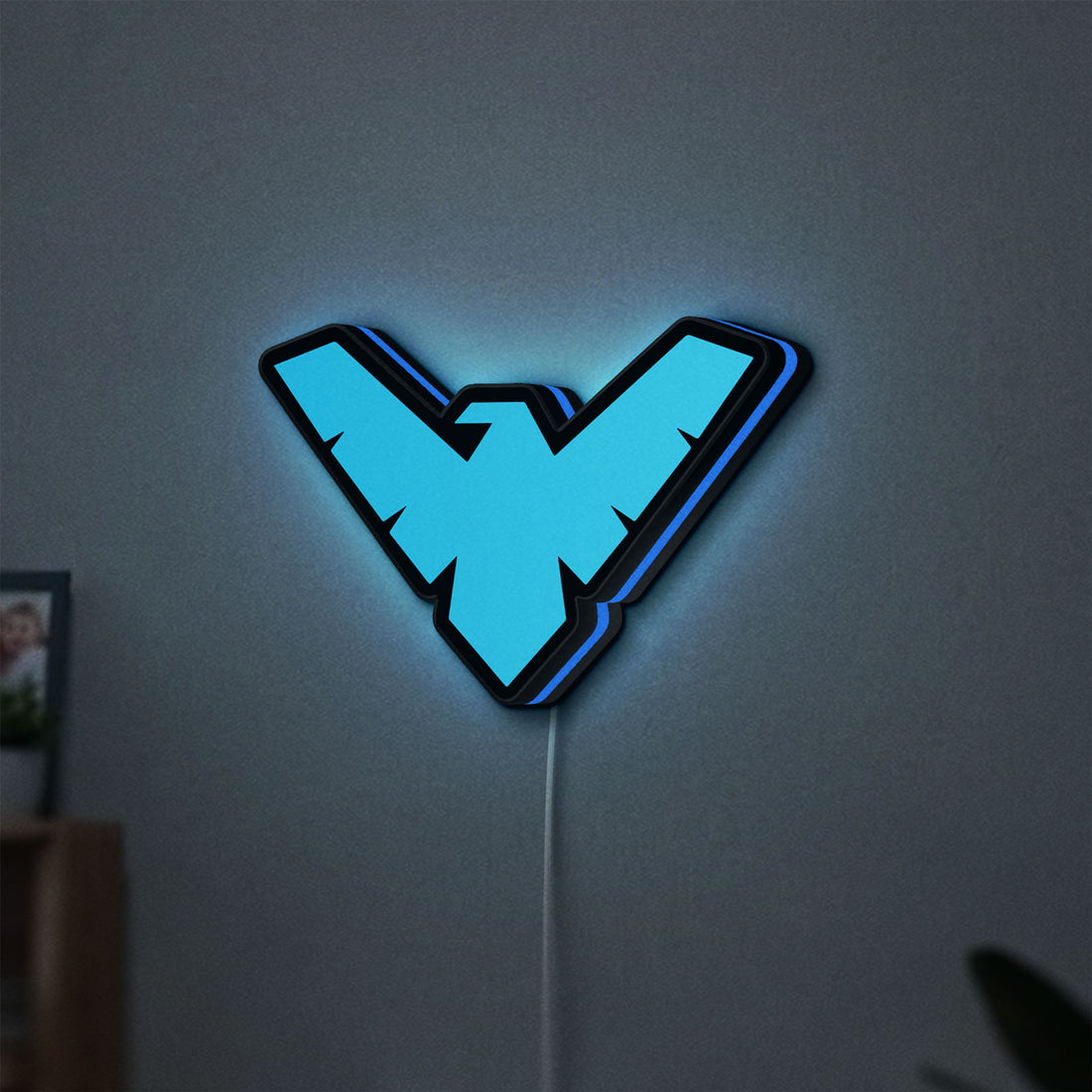 Nightwing LED lightbox hanging on a wall with blue glow