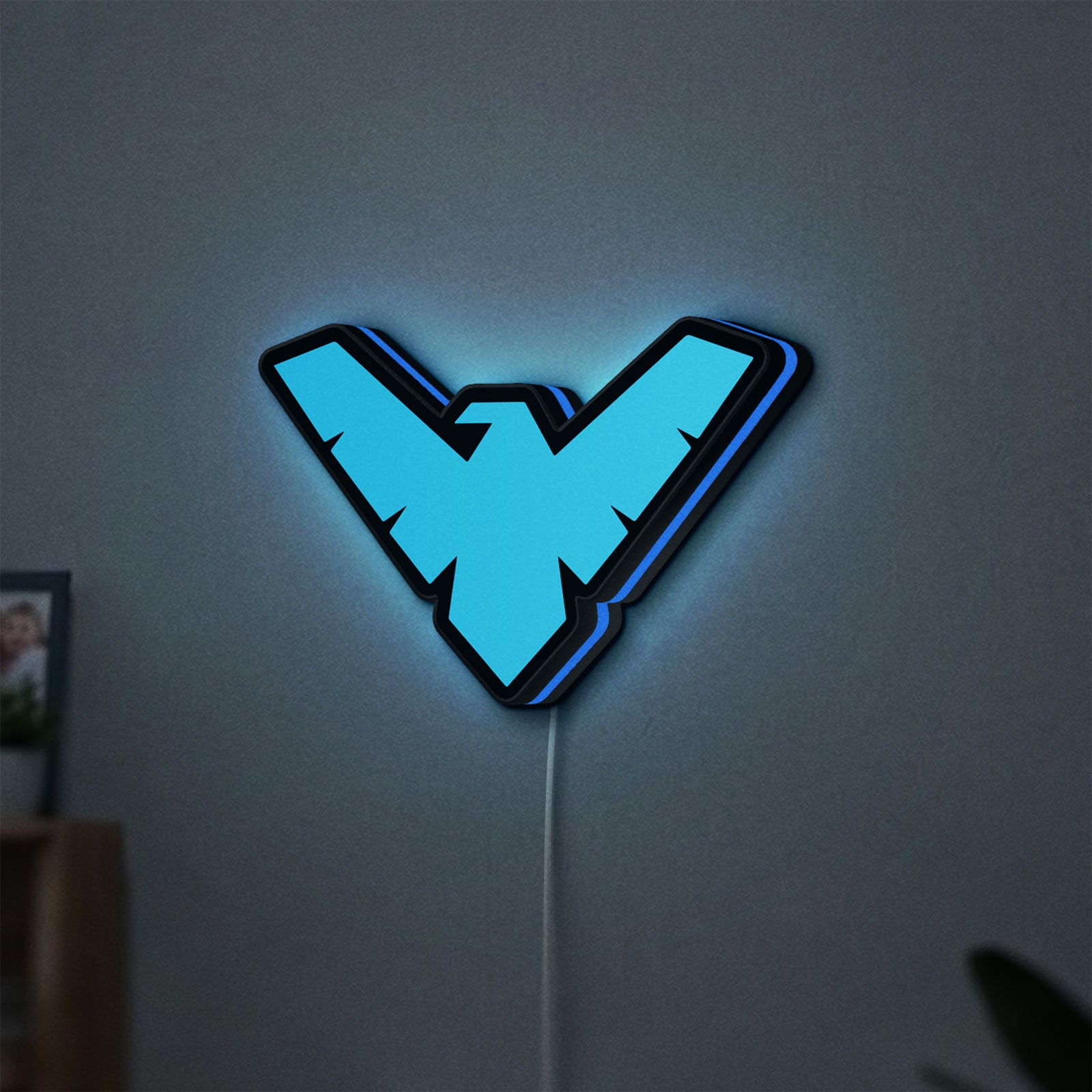 Nightwing LED lightbox hanging on a wall with blue glow