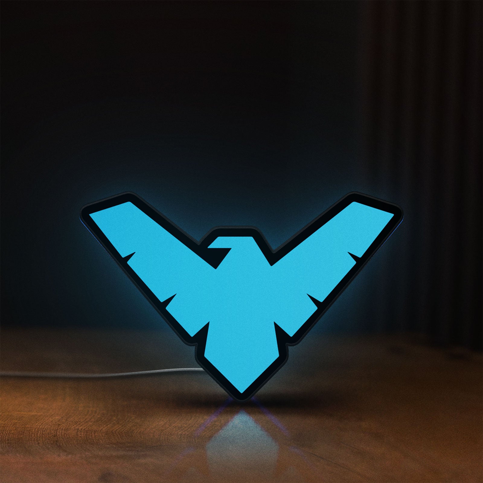 Front view of Nightwing LED lightbox sign glowing on a wooden desk