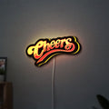 Cheers LED lightbox hanging on a wall with yellow glow