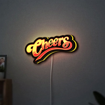 Cheers LED lightbox hanging on a wall with yellow glow