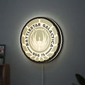 Battlestar Galactica Colonial Emblem LED lightbox hanging on a wall with white glow