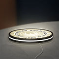 Battlestar Galactica Colonial Emblem LED lightbox lying flat on a desk with white glow