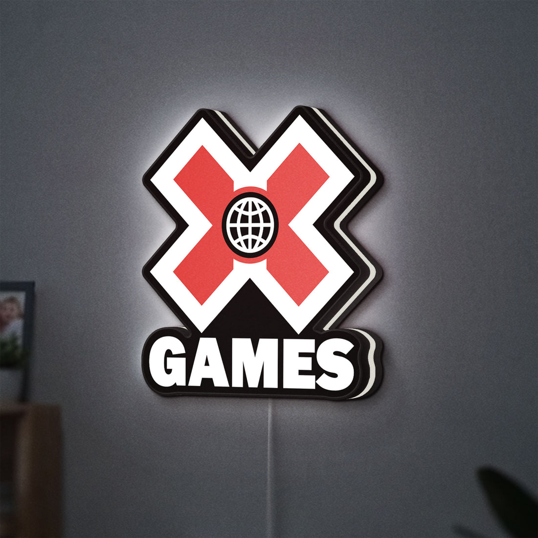 X-Games LED lightbox hanging on a wall with white glow