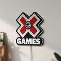 Unlit X-Games LED lightbox mounted on a wall in daylight