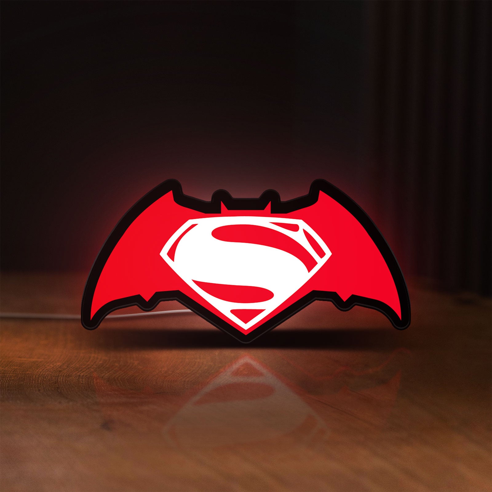 Front view of Batman v Superman LED lightbox sign glowing on a wooden desk