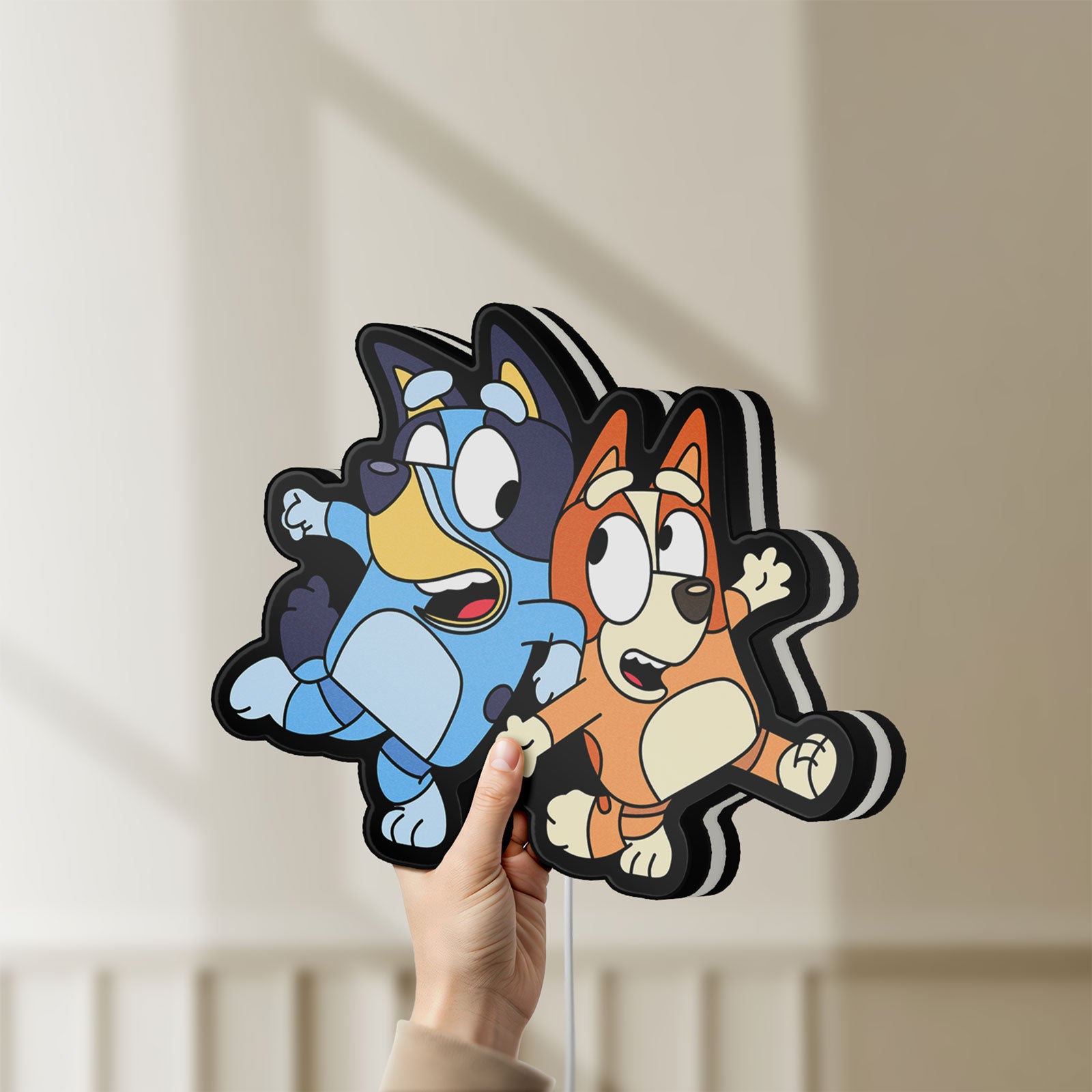 Unlit Bluey LED lightbox held by hand to show size and details