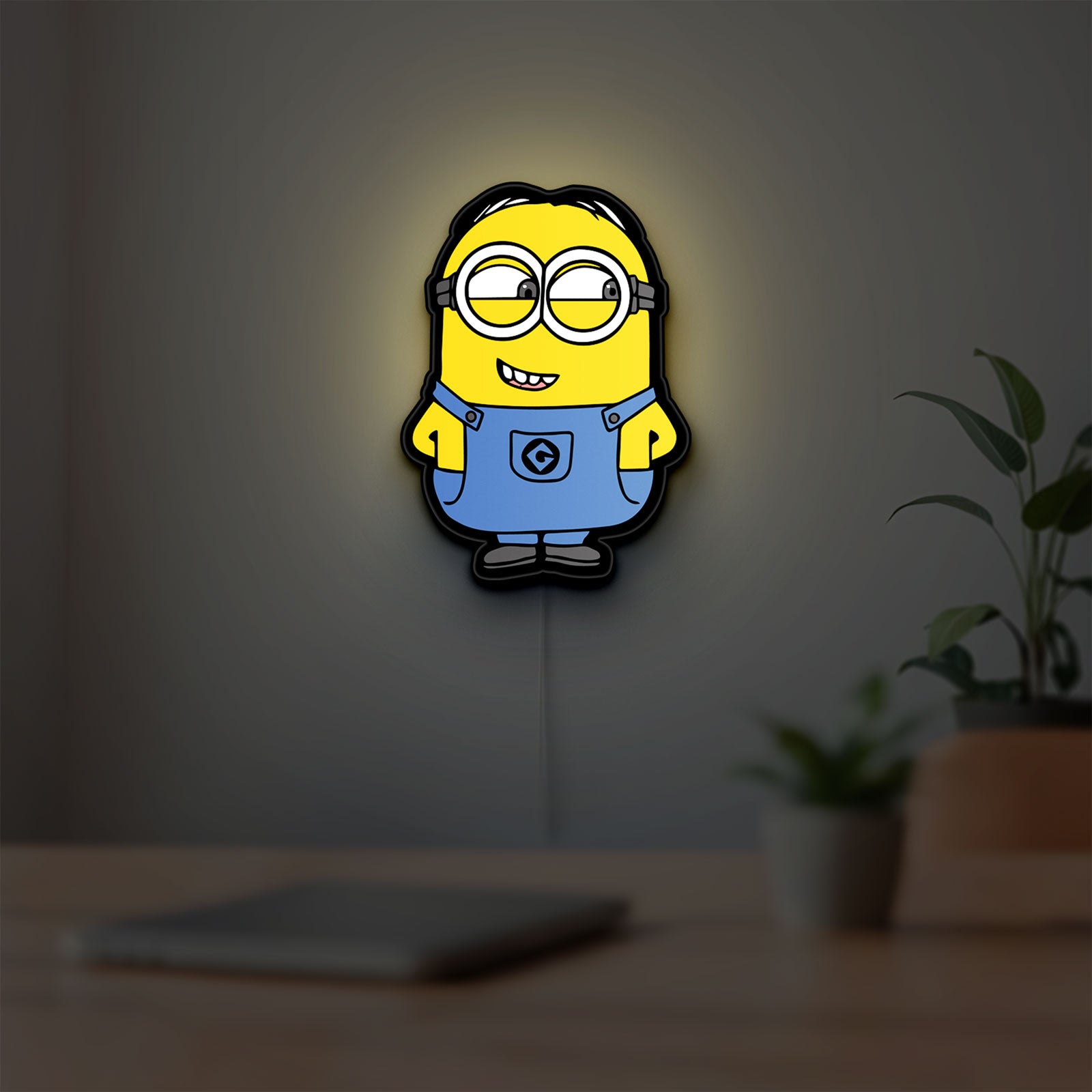 Minions Character LED lightbox hanging on a room wall with soft yellow light
