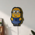 Unlit Minions Character LED lightbox mounted on a wall in daylight
