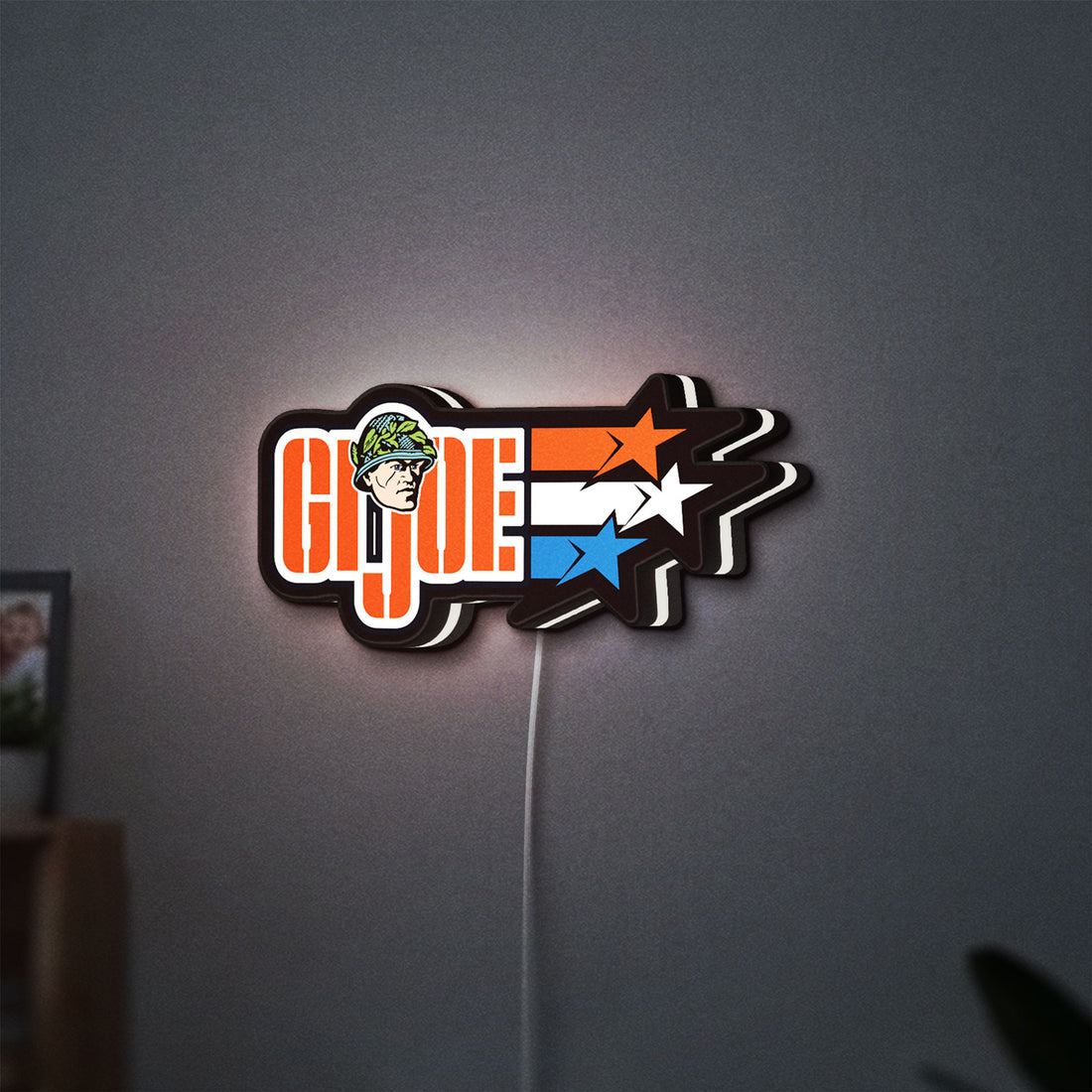 G.I. Joe LED lightbox hanging on a wall with white glow