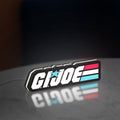G.I. Joe LED lightbox standing on a desk from an angled side view with white glow
