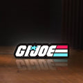 Front view of G.I. Joe LED lightbox sign glowing on a wooden desk